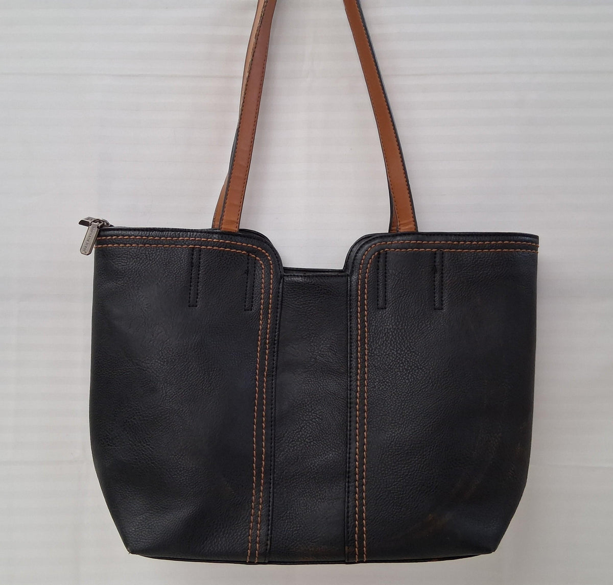 Black faux leather tote with brown handles and brown accent stitching, view 4