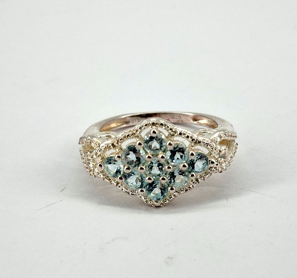 Silver cluster ring stamped 925 with round blue stones and scrollwork shoulders, view 3
