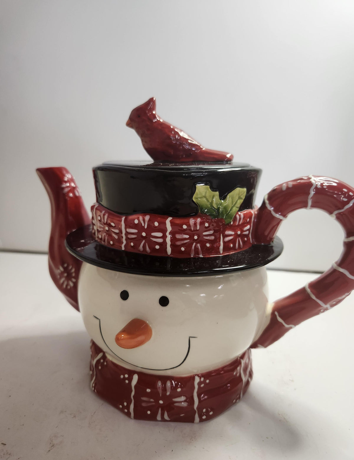 Ceramic snowman teapot with red plaid scarf and hat and red cardinal on the lid, view 5