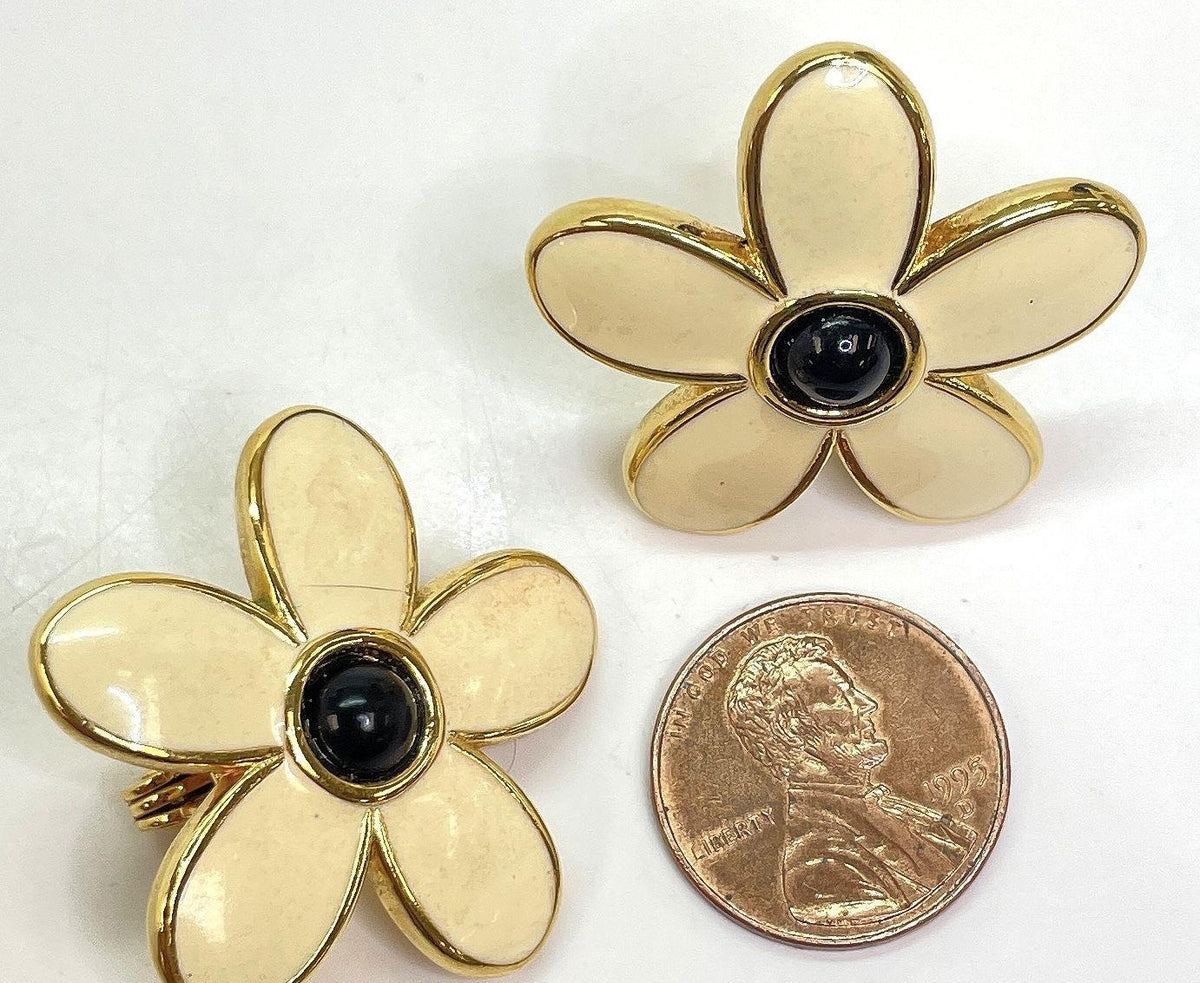 Signed Monet gold-tone clip-on earrings with cream enamel petals and black stone centers, view 2