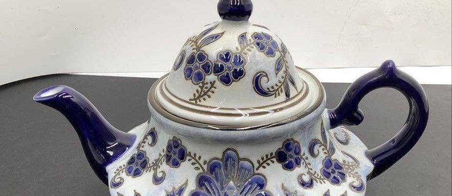 White ceramic teapot with cobalt blue floral and scroll decoration and finial lid, view 2