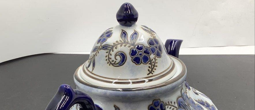 White ceramic teapot with cobalt blue floral and scroll decoration and finial lid, view 3
