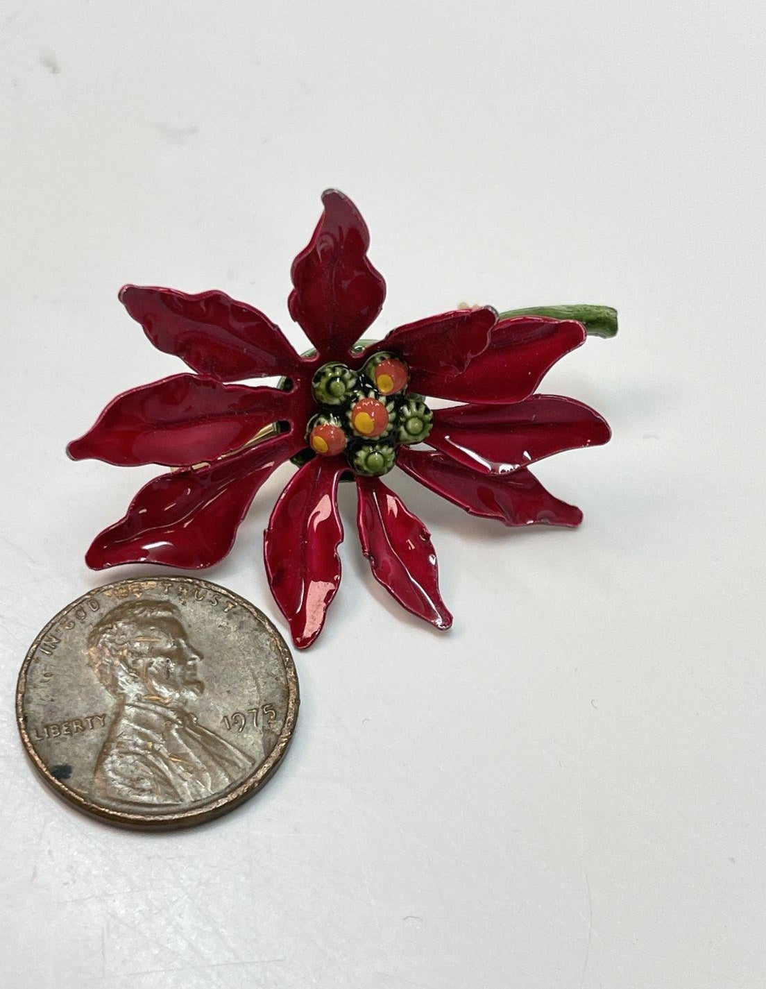 Gold-tone poinsettia brooch with red enamel petals and green enamel leaves, view 3