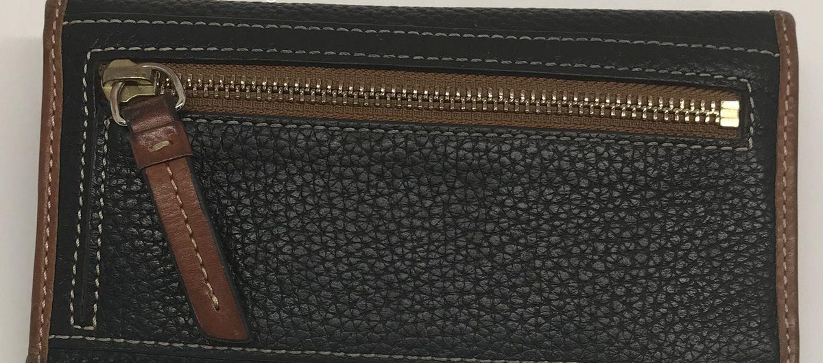 Dooney and Bourke black pebble grain leather clutch wallet with brown trim and front plaque, view 6