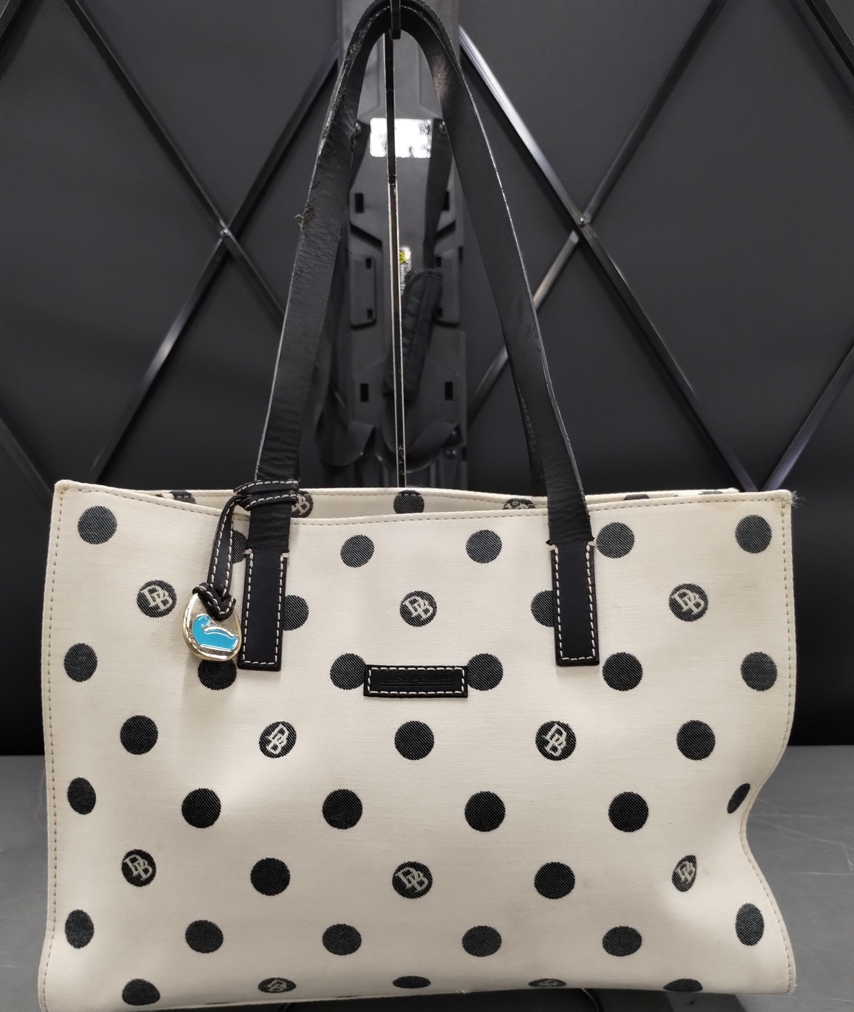 Dooney and Bourke cream canvas tote with black polka dots, black leather straps and blue duck charm, view 2
