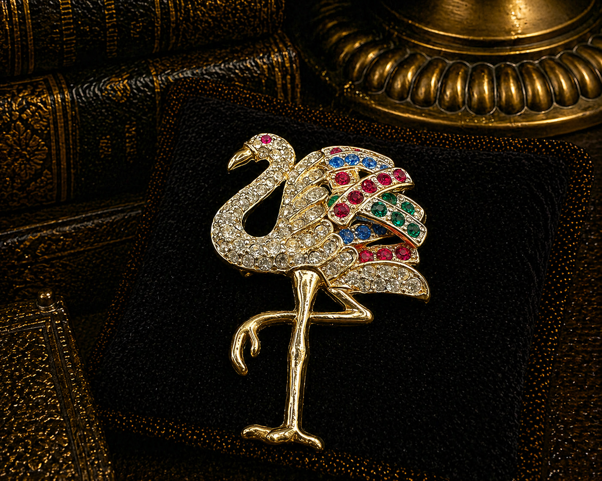 Gold-tone standing flamingo brooch with clear crystals and red, blue and green wing accents