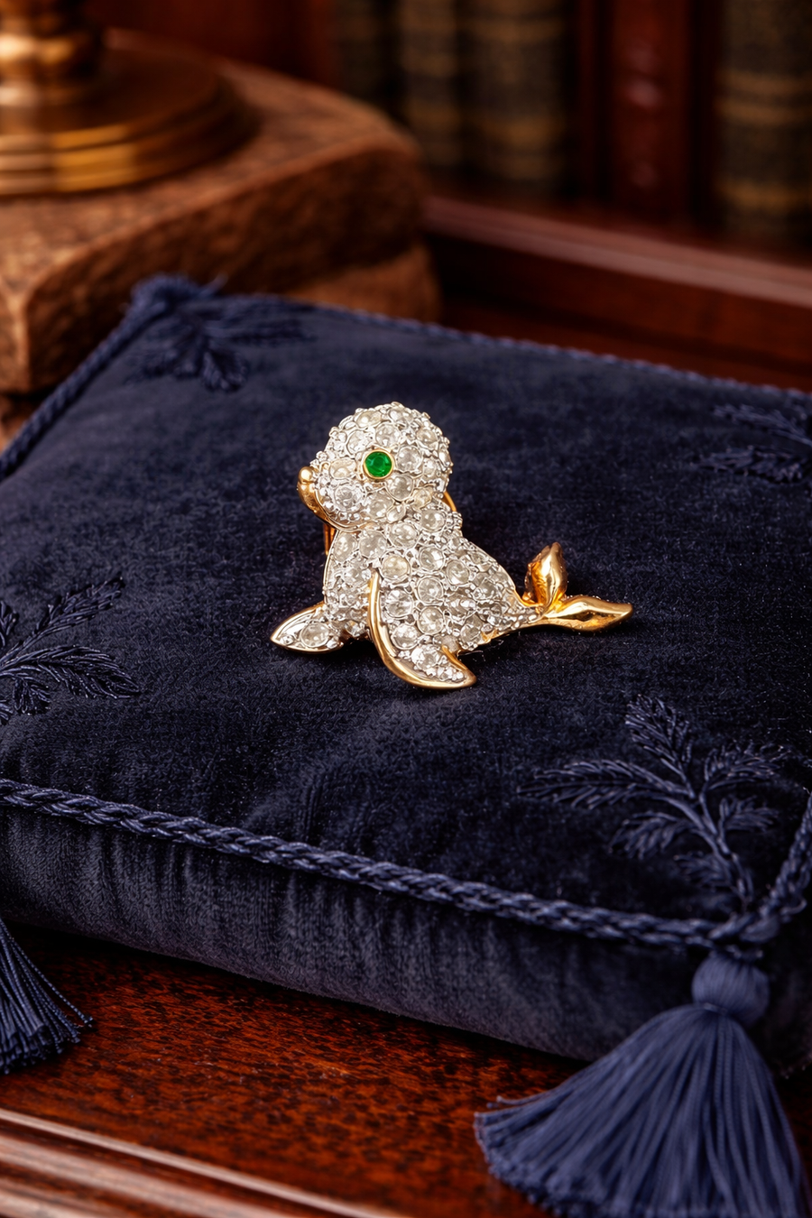 Gold-tone seal brooch with clear pavé crystals and green crystal eye