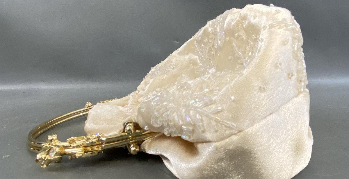 Off-white cream gathered clutch with gold-tone top handle frame and floral rhinestone accents, view 2