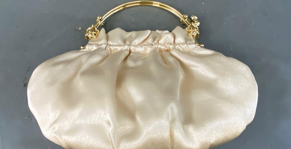 Off-white cream gathered clutch with gold-tone top handle frame and floral rhinestone accents, view 3