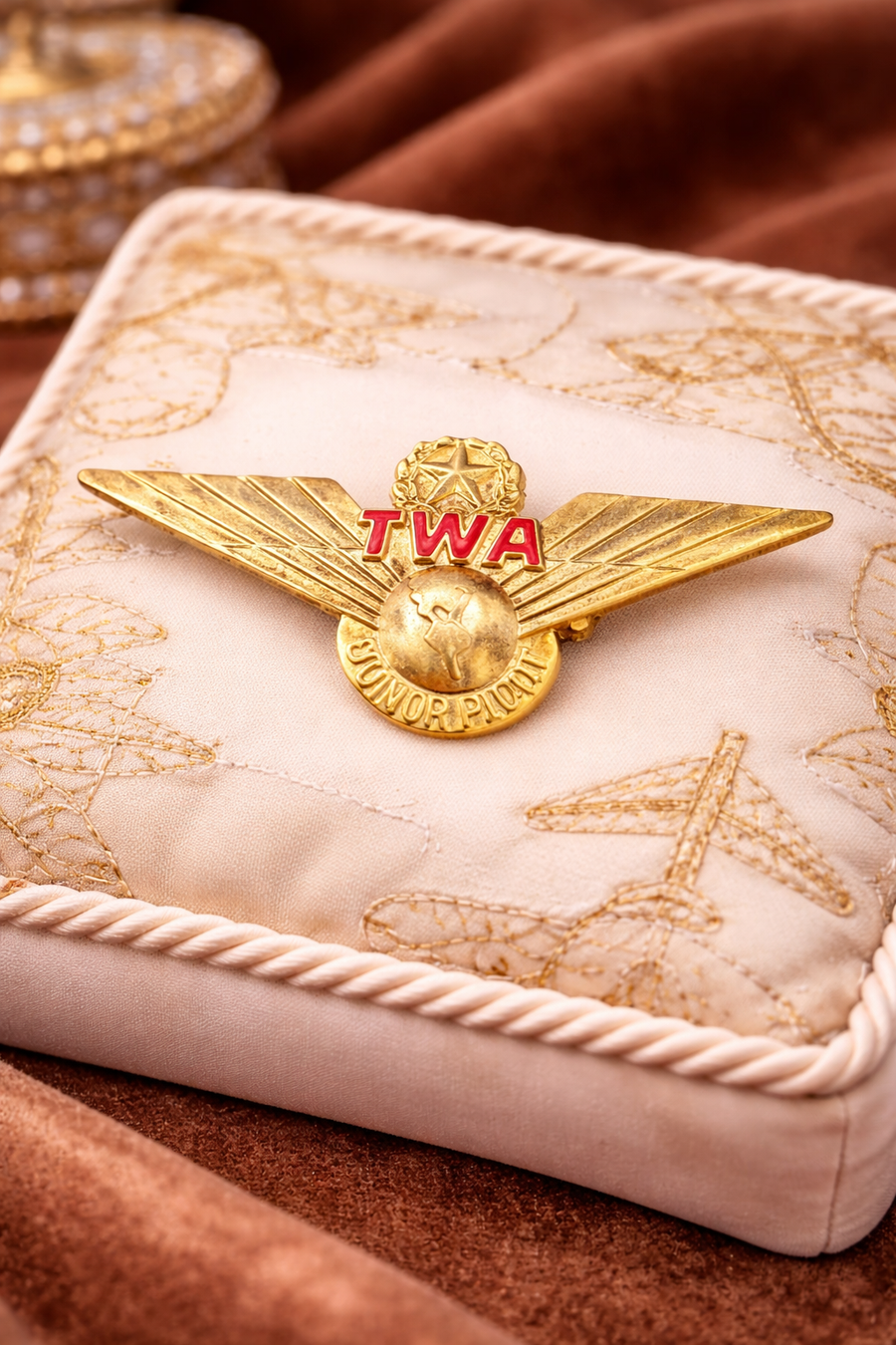 Gold-tone TWA Junior Pilot wing pin with red TWA lettering and round center medallion