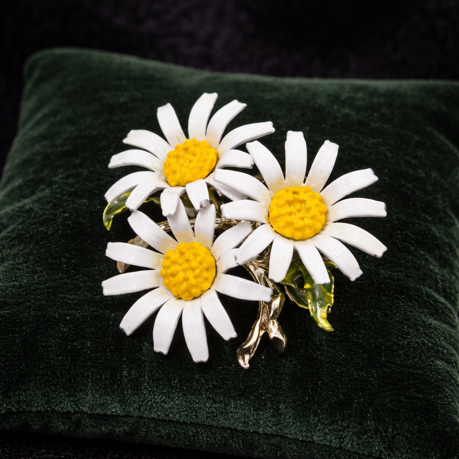 Gold-tone brooch with a cluster of white enamel daisies and yellow centers