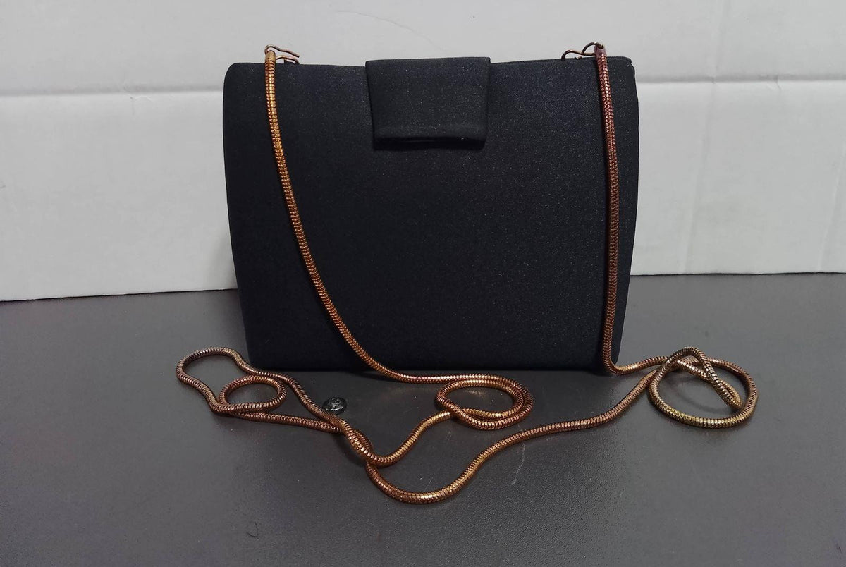 Black structured evening clutch with gold-tone bow clasp and slim chain strap, view 2