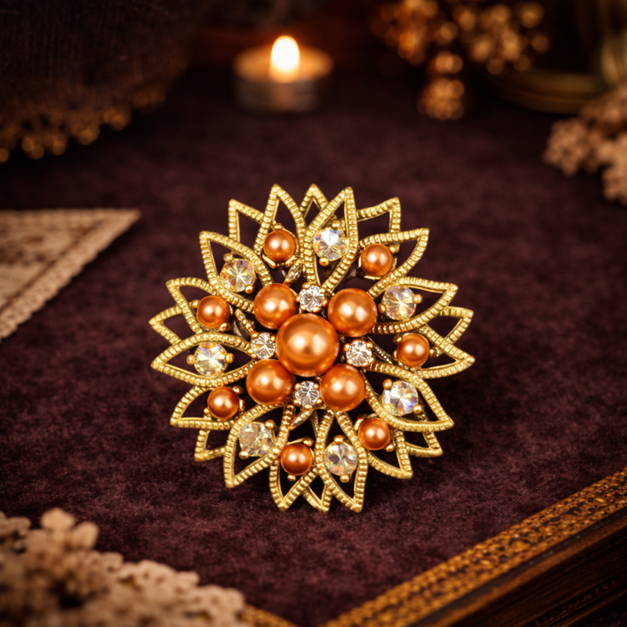 Gold-tone sunburst flower brooch with amber-toned faux pearl cluster and rhinestones