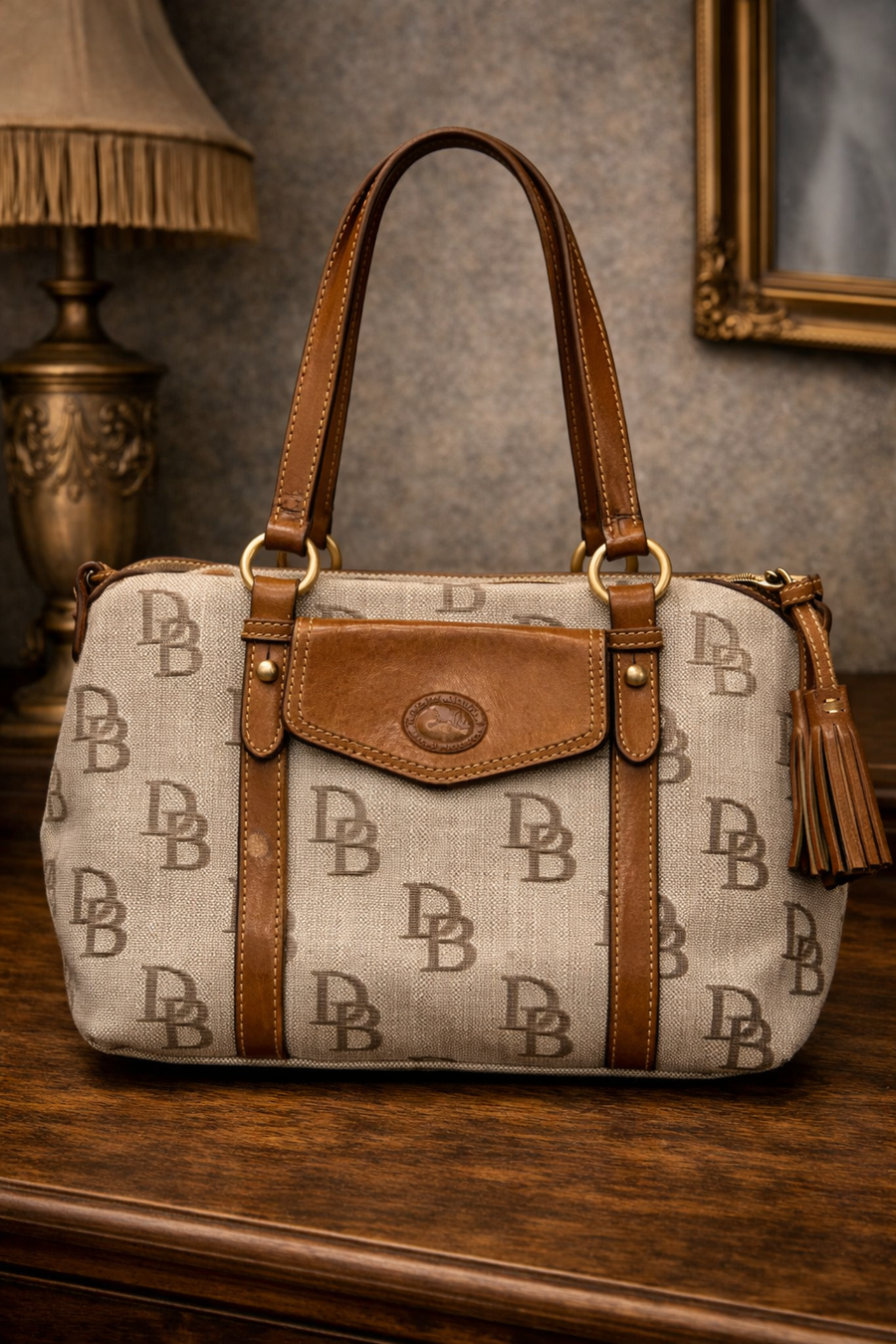 Dooney and Bourke DB monogram canvas barrel satchel with leather trim, rolled handles and tassel