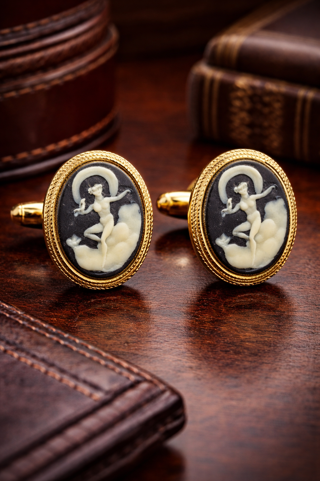 Gold-tone oval cameo-style cufflinks with raised light figure on dark ground
