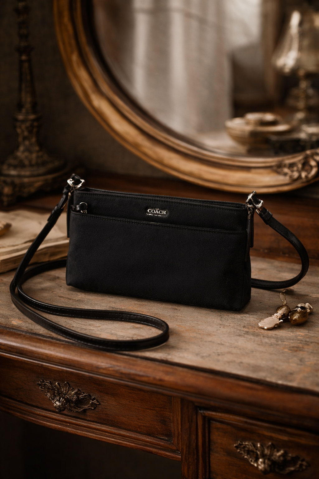 Coach small black leather crossbody clutch with silver-tone hangtag