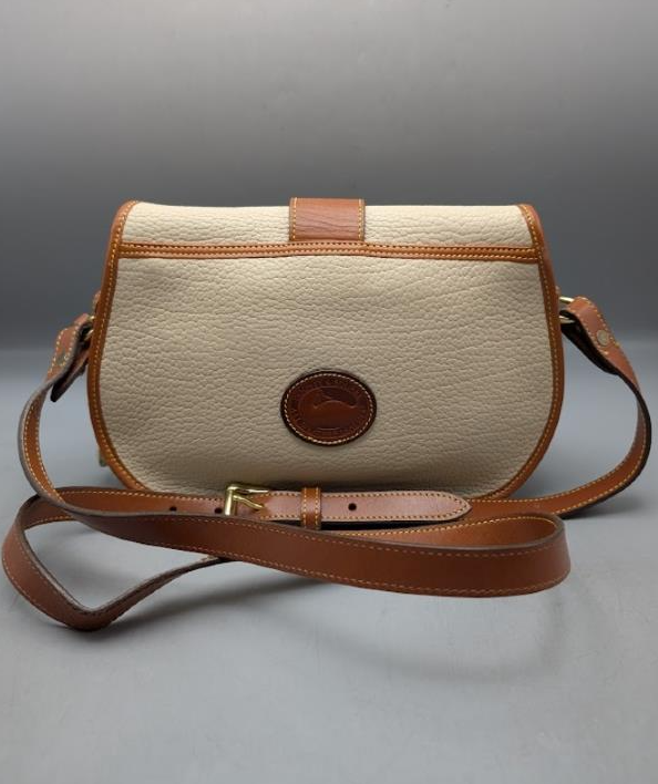 Dooney and Bourke cream pebbled leather saddle crossbody with tan trim and brass-tone duck closure, view 10