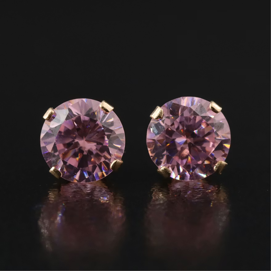 Pair of gold stud earrings marked 14K with round faceted pink-lavender cubic zirconia