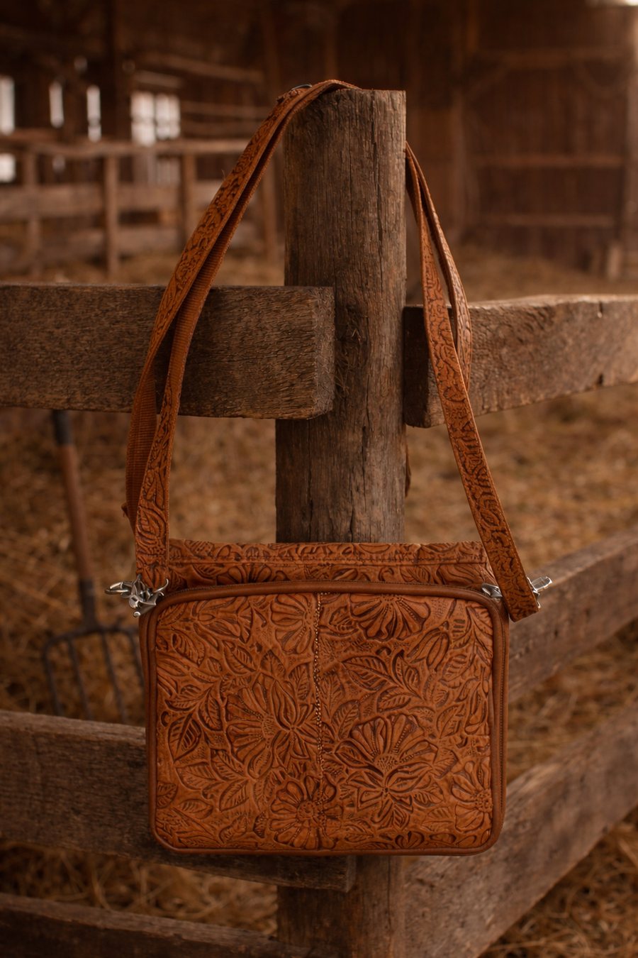 Brown floral tooled leather crossbody bag with flap pocket and zip top