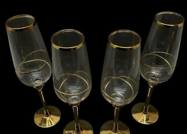 Four tall clear champagne flutes with gold-tone stems, view 2
