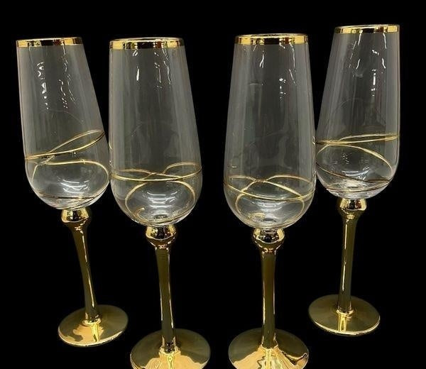 Four tall clear champagne flutes with gold-tone stems, view 4
