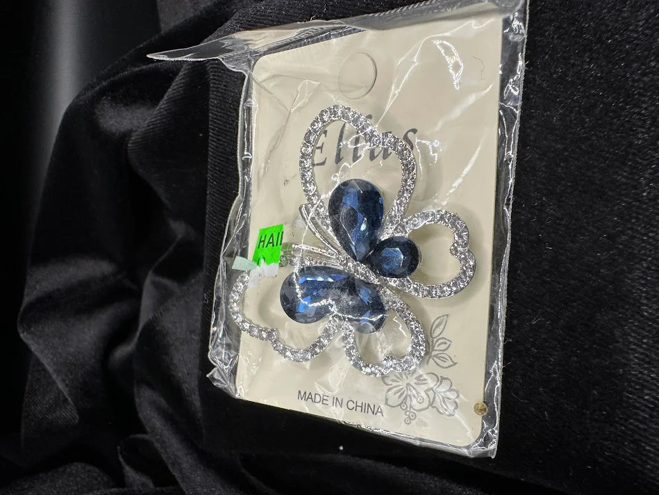 Silver-tone openwork butterfly brooch with deep blue crystal wings on display card, view 3