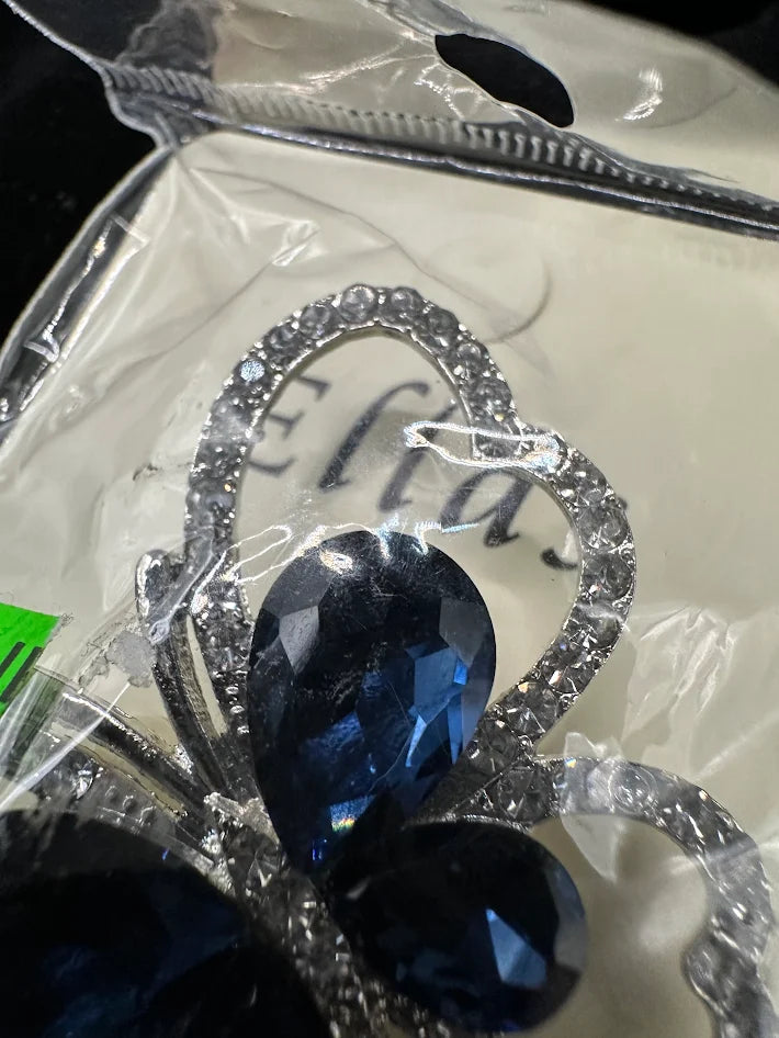 Silver-tone openwork butterfly brooch with deep blue crystal wings on display card, view 4