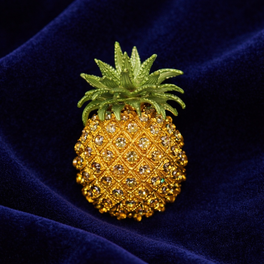 Signed Rucinni gold-tone pineapple brooch with golden pavé rhinestones and green leaves