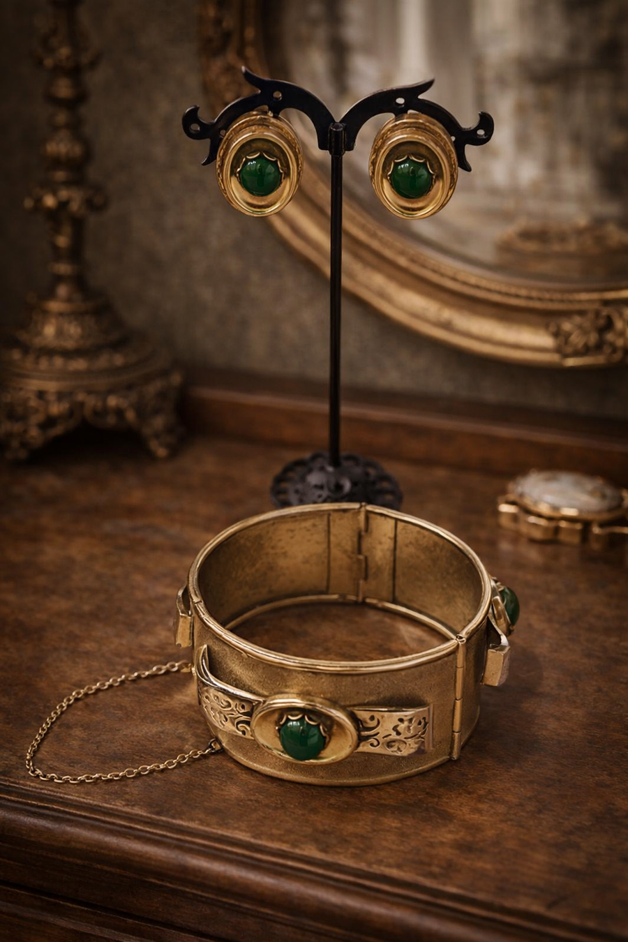 Signed Whiting and Davis gold-tone hinged bracelet and clip-on earrings with green cabochons