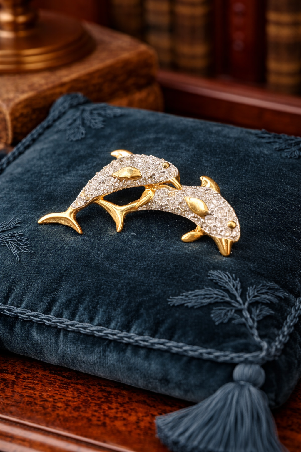 Gold-tone double dolphin brooch with clear rhinestones in a crossing design