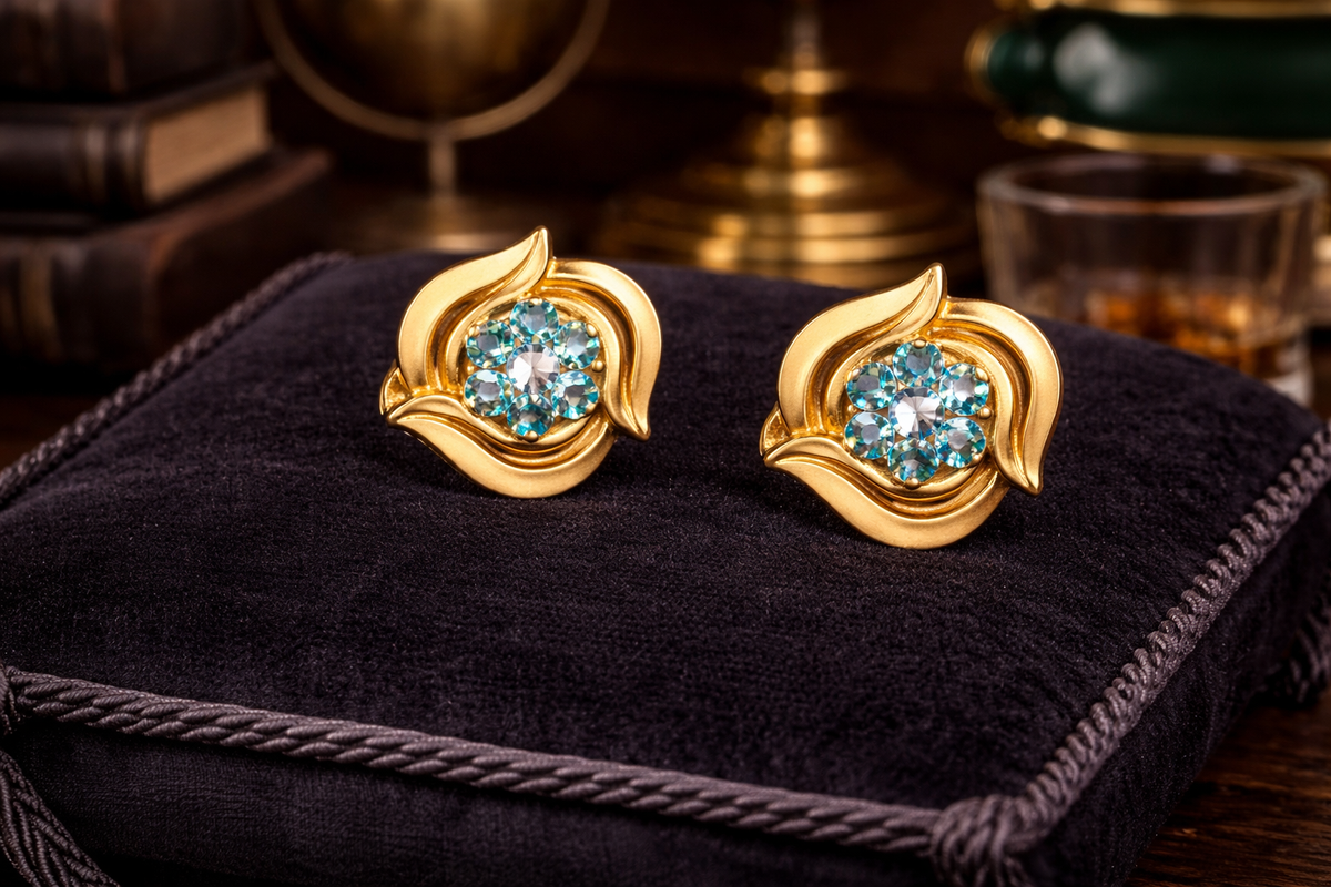 Gold-tone swirl floral clip-on earrings with faceted blue crystal centers