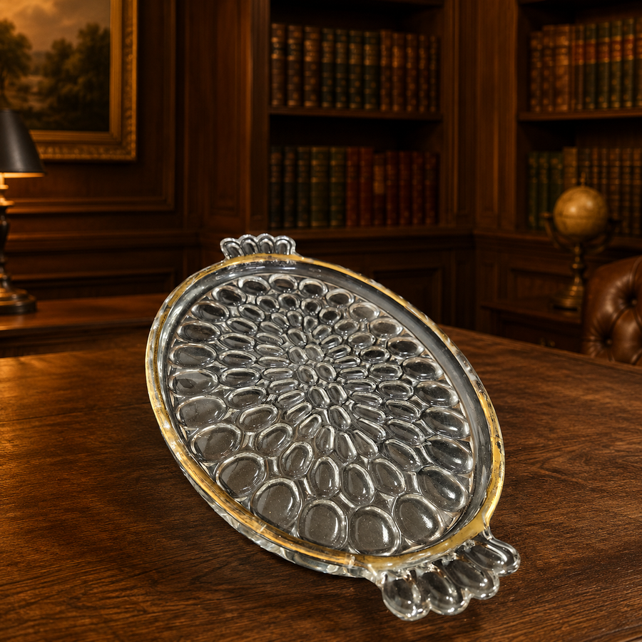 Clear oval textured glass serving tray on small feet with fading gold-tone rim