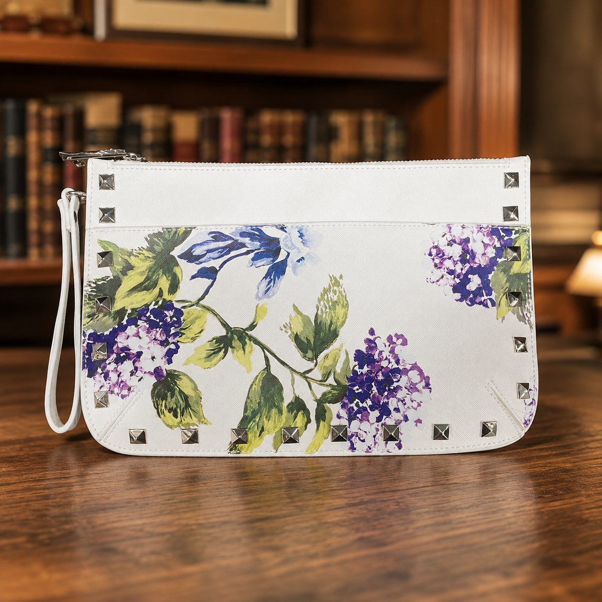 White wristlet clutch with blue and purple hydrangea print and silver-tone stud trim