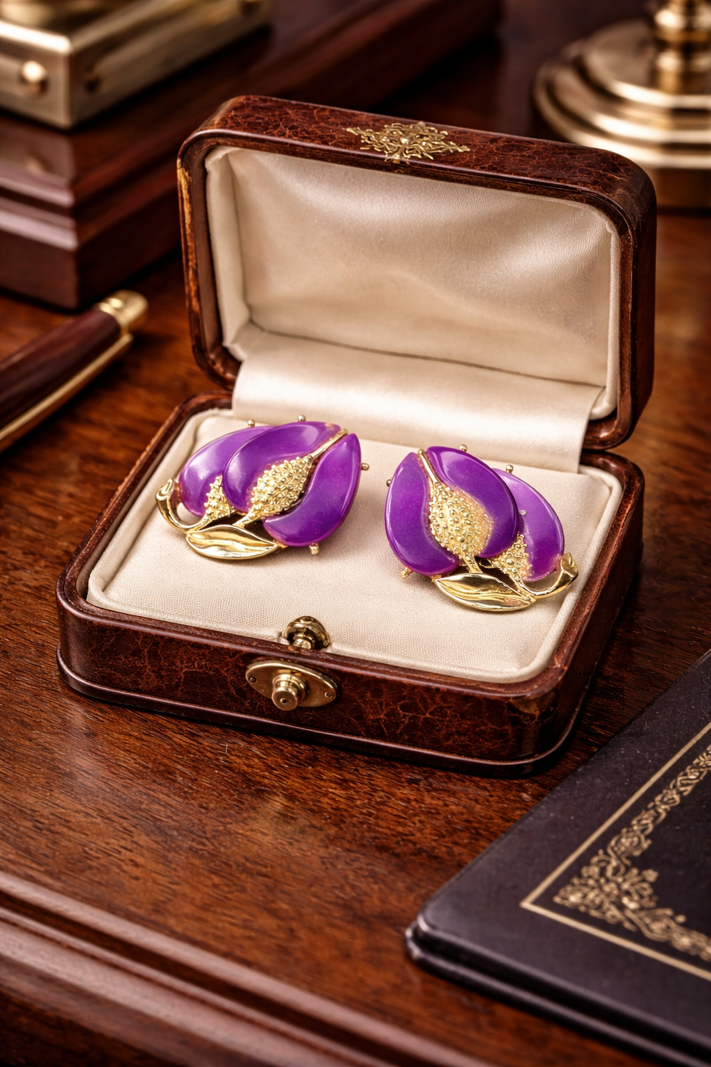 Gold-tone clip earrings with purple enamel petals and curved gold-tone leaves