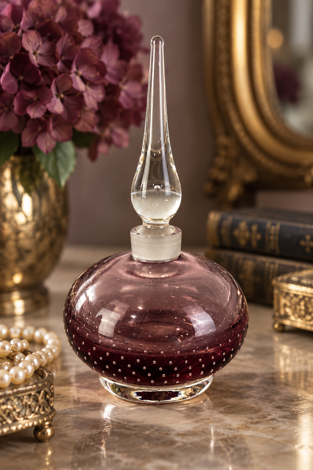 Amethyst-pink controlled bubble art glass bottle with clear foot and tall clear spire stopper