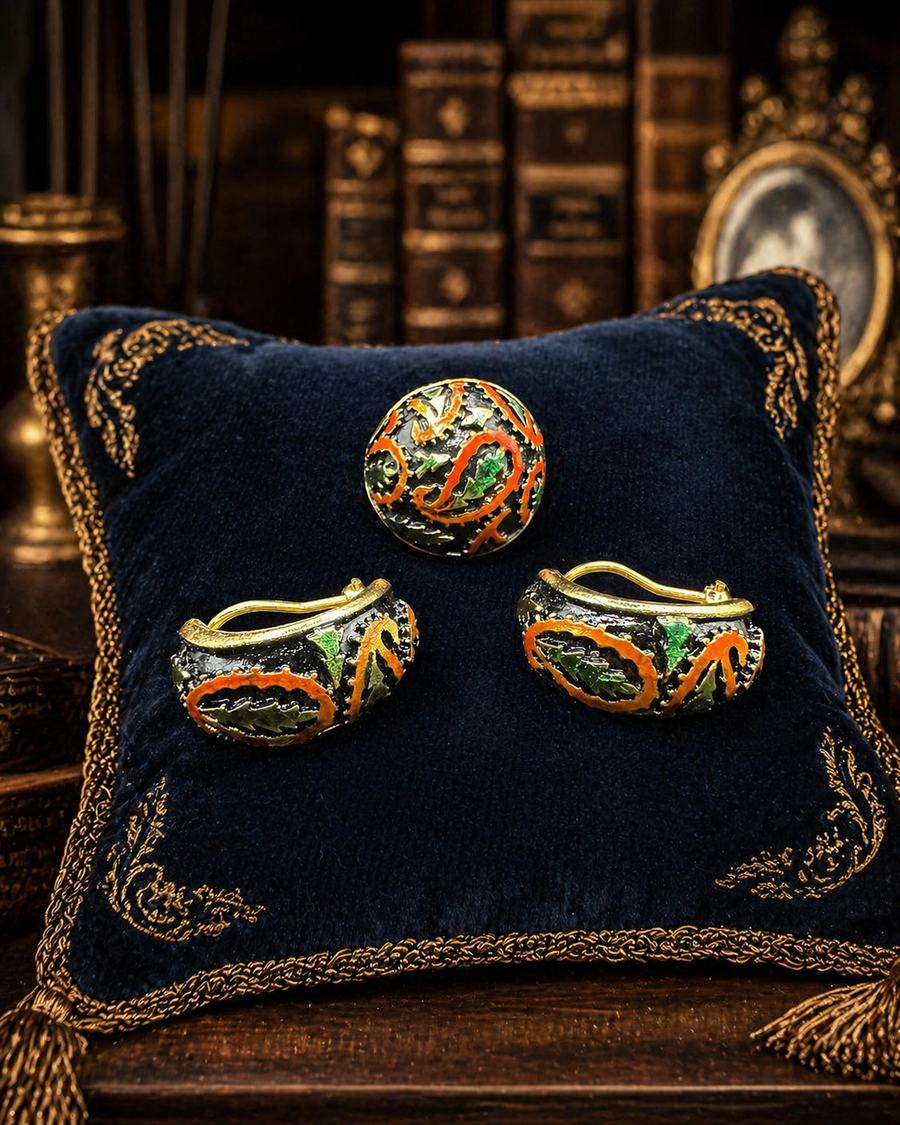 Gold-tone ring and clip earrings with black ground, raised orange scrollwork and green leaves