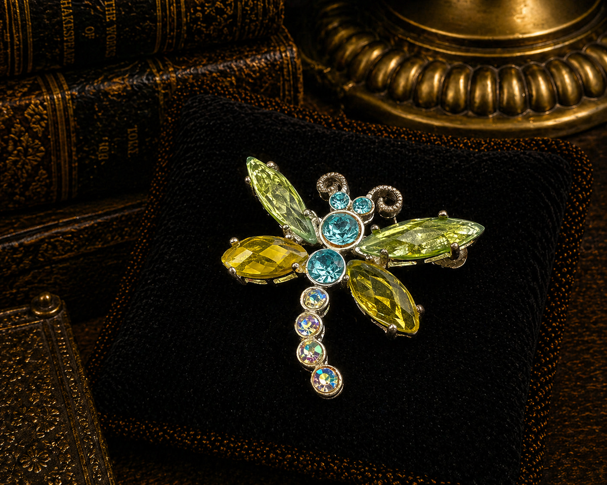 Silver-tone dragonfly brooch with green marquise crystal wings and blue crystal body
