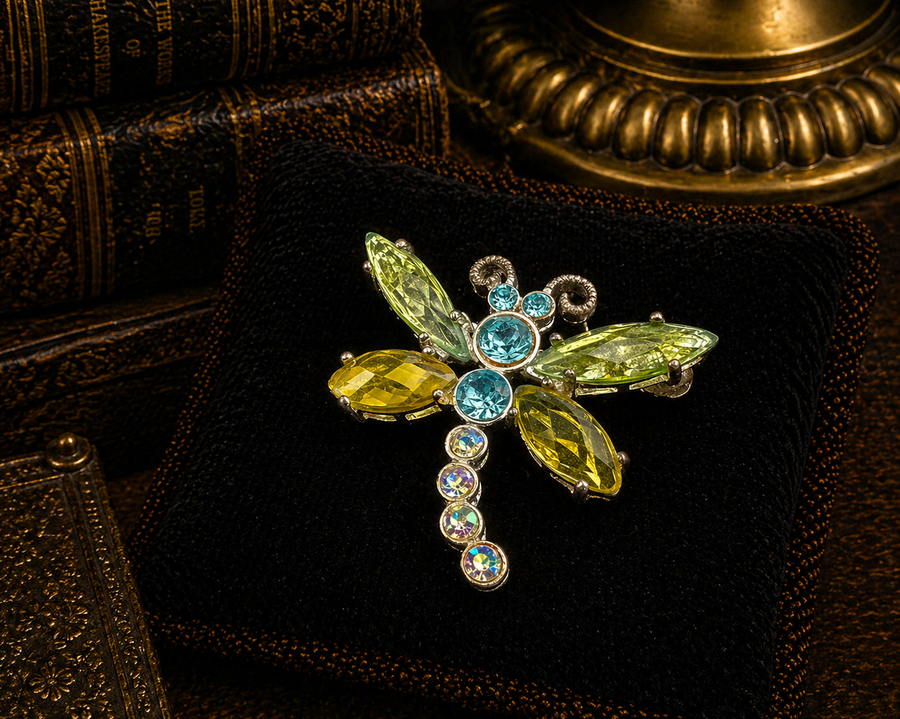 Silver-tone dragonfly brooch with green marquise crystal wings and blue crystal body