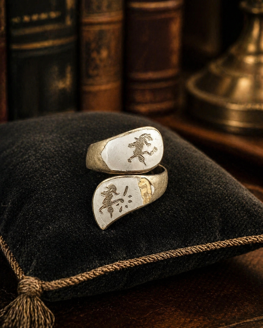 Two-tone silver and gold-tone bypass wrap ring with pale enamel-style panels and etched figures