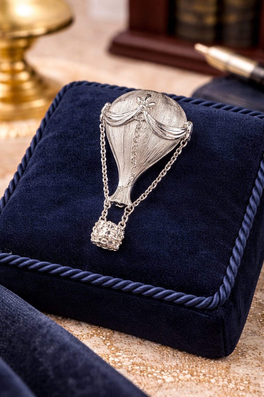 Silver-tone hot air balloon brooch with textured canopy and basket suspended on chains