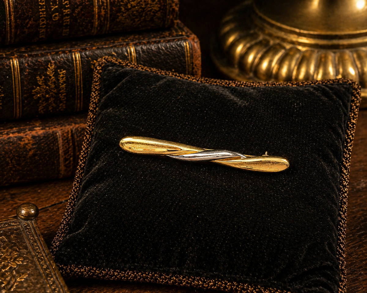 Slim gold-tone bar brooch with silver-tone curved accent
