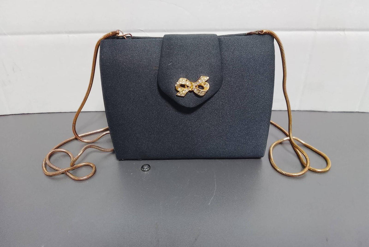 Black structured evening clutch with gold-tone bow clasp and slim chain strap, view 3