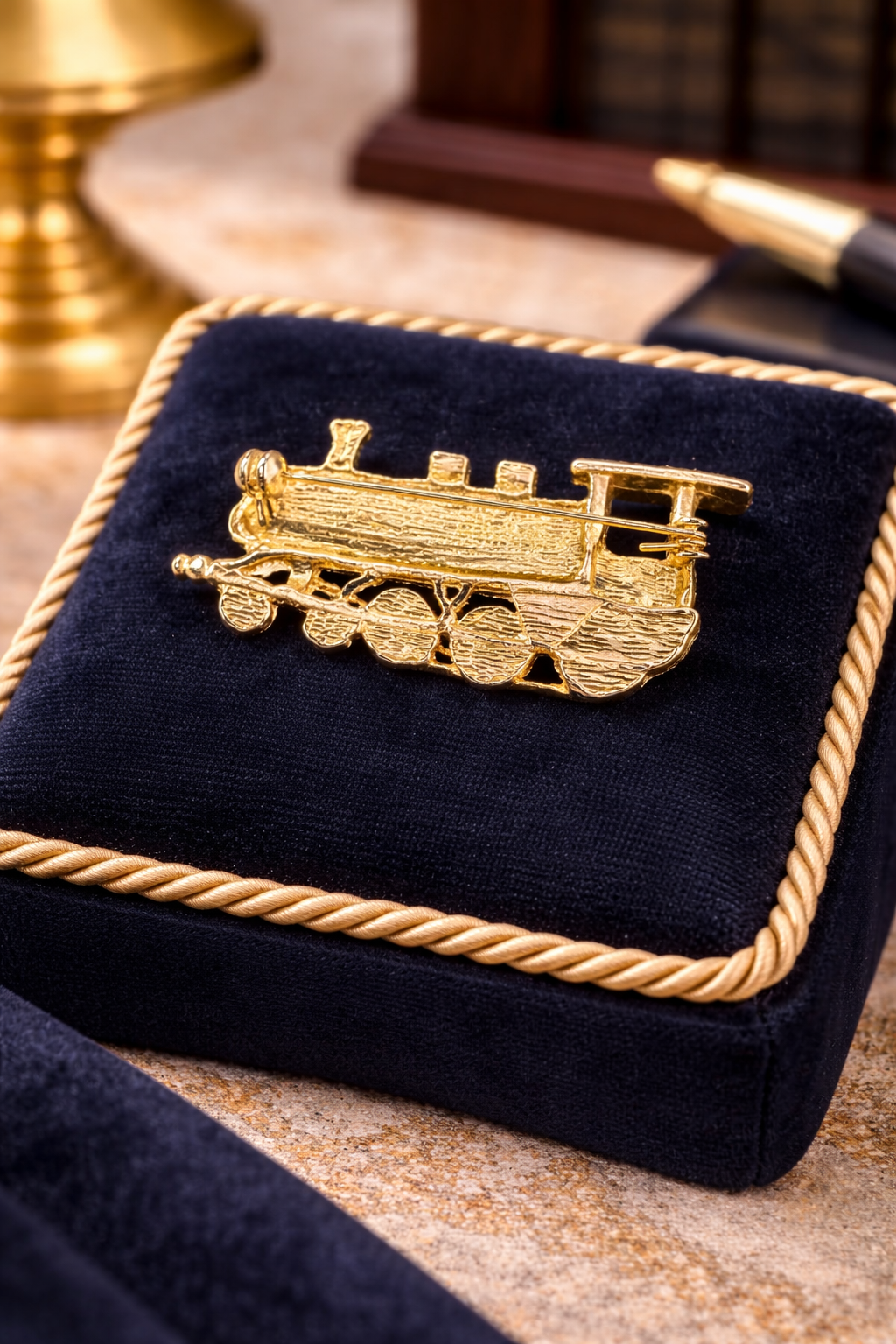 Gold-tone steam locomotive brooch with smokestack, cab, cowcatcher and raised wheels