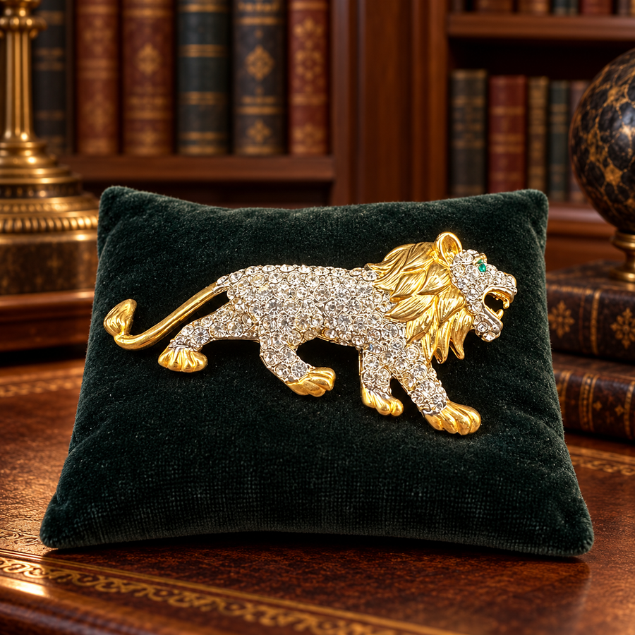 Gold-tone striding lion brooch with clear crystal body and green eye