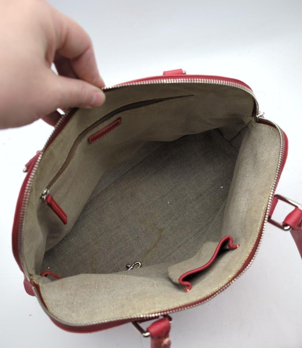 Dooney and Bourke red pebbled leather domed satchel with cream contrast stitching and rolled handles, view 8