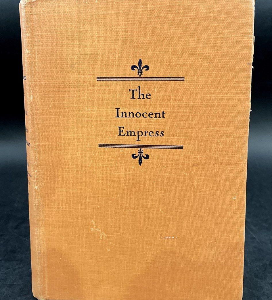 The Innocent Empress by Erna Barschak, orange-tan cloth hardcover with fleur-de-lis stamping, view 2