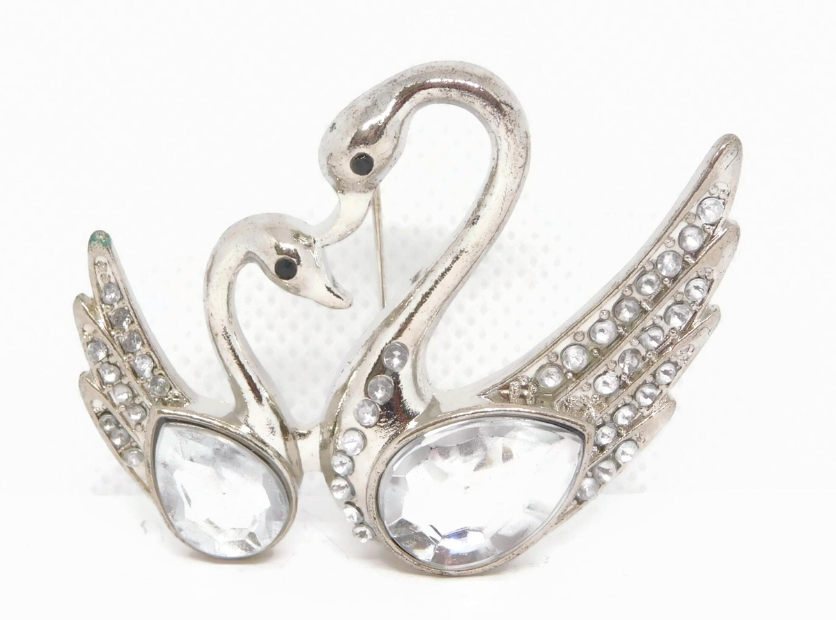 Silver-tone brooch of two swans head to head with clear rhinestone bodies and pavé wings, view 2