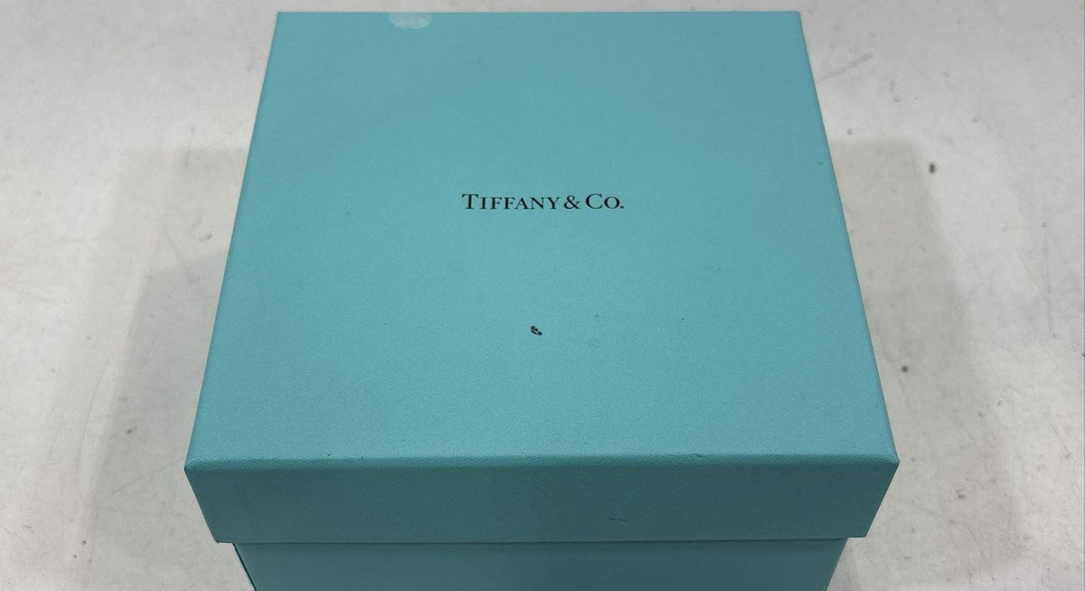 Clear rock cut glass serving bowl with faceted sides beside a blue presentation box, view 2