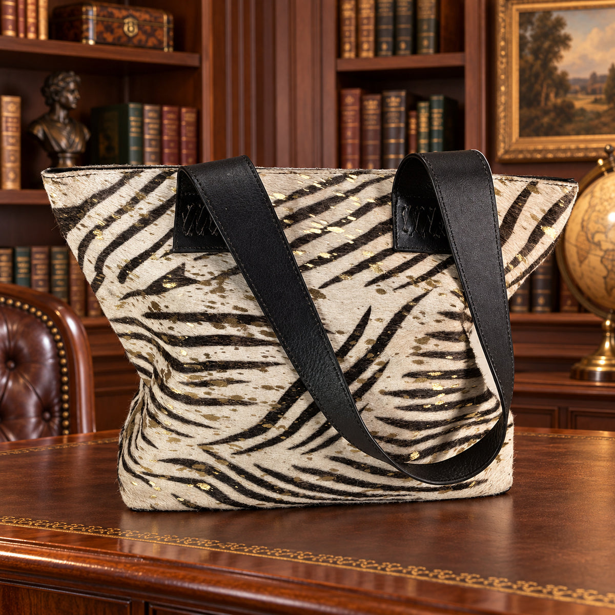 Black and cream zebra print hair-on texture tote with gold splatter and black shoulder straps