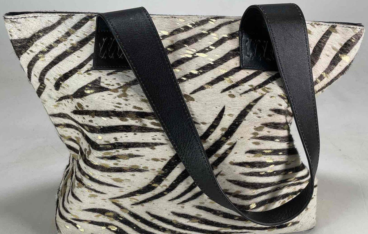 Black and cream zebra print hair-on texture tote with gold splatter and black shoulder straps, view 2